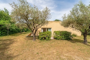 A small building with a window, surrounded by trees and dry grass. - Gite 'Gite Du Petit Bois' with Shared Pool, Wi-Fi, and Air Conditioning (Villedieu)