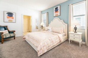 A bedroom with a bed, a nightstand, a chair, and a door. - Disney Getaway! Luxury Villa with Private Pool & Game Room. Book Now! #CG886 (Orlando)