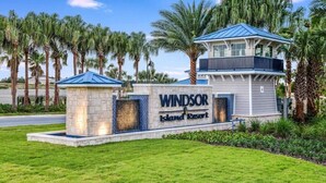 Un complex turístic anomenat 'Windsor Island Resort' amb un cartell destacat, un edifici de dues plantes i palmeres al fons.