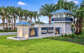 Ein Resort namens 'Windsor Island Resort' mit auffälliger Beschilderung, einem zweistöckigen Gebäude und Palmen im Hintergrund.