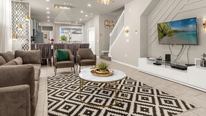 Ein modernes Wohnzimmer mit einer Couch, Sesseln, einem Couchtisch und einem Fernseher.
