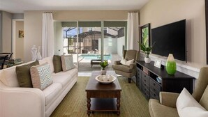 A modern living room with a white sofa, a wooden coffee table, and a TV on a black stand. - Last Minute Disney Getaway! Townhouse with Private Pool. Book Now! #136377 (Orlando)