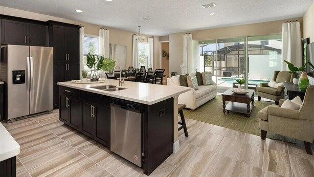 A modern kitchen with a large island, dark cabinetry, and stainless steel appliances. - Last Minute Disney Getaway! Townhouse with Private Pool. Book Now! #136377 (Orlando)