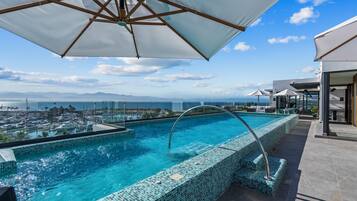 Piscine extérieure, parasols de plage, chaises longues