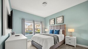 A bedroom with a bed, bedside tables, a TV, and a window. - Last Minute Disney Getaway! Private Pool & Themed Bedrooms. Book Now! #161419 (Orlando)