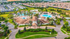 A residential area with a large building featuring a swimming pool and landscaped gardens. - Last Minute Disney Getaway! Private Pool, Game Room & Themed Bedrooms. Book Now! #162951 (Orlando)