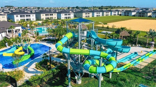 A water park with multiple slides and a pool area, surrounded by residential buildings. - Last Minute Disney Getaway! Private Pool, Game Room & Themed Bedrooms. Book Now! #162951 (Orlando)