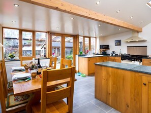 Una cocina moderna con armarios de madera, una isla central y ventanas amplias.