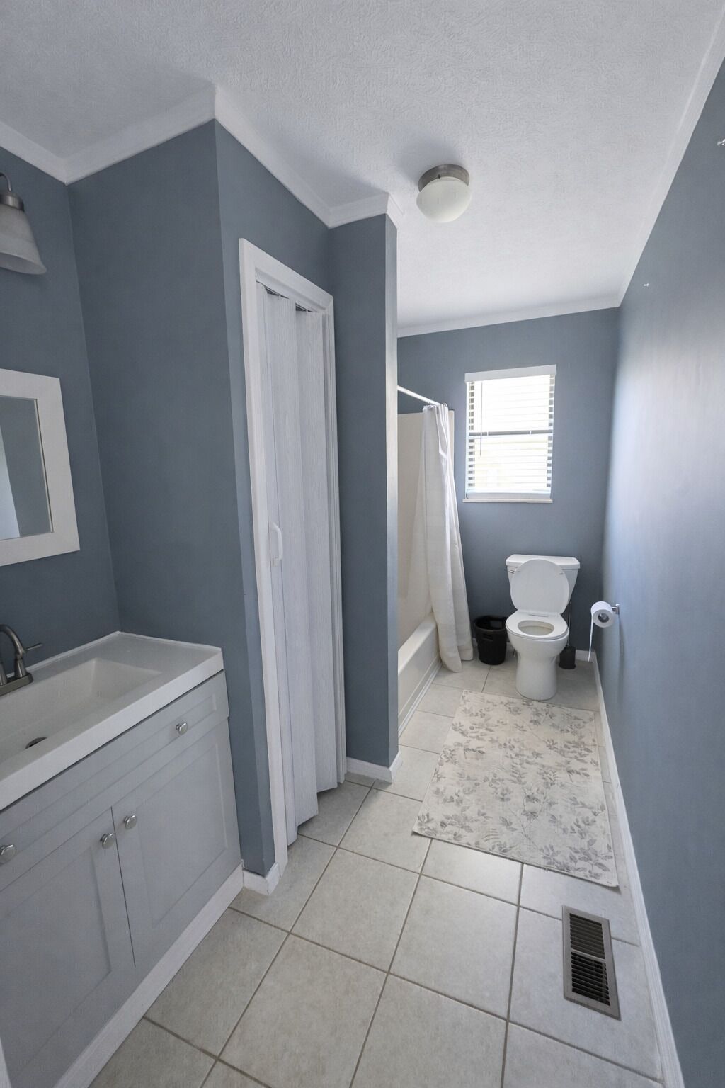 A bathroom with a sink, toilet, and shower area.