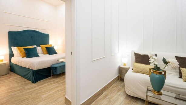 Ett modernt hotellrum med en säng, ett sängbord och en soffa.