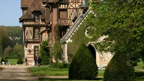A large, historic building with a prominent staircase, surrounded by well-maintained gardens and a clear sky. - Manoir de Villers (Saint-Pierre-de-Manneville)