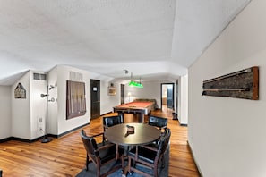 A room with a pool table, a billiards table, and a dining table with chairs. - Gorgeous 5-bedroom Riverside Estate Lodge in downtown Townsend (Townsend)