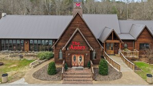 A wooden building with a sign reading "The Abbey" and a steeple with a heart symbol.