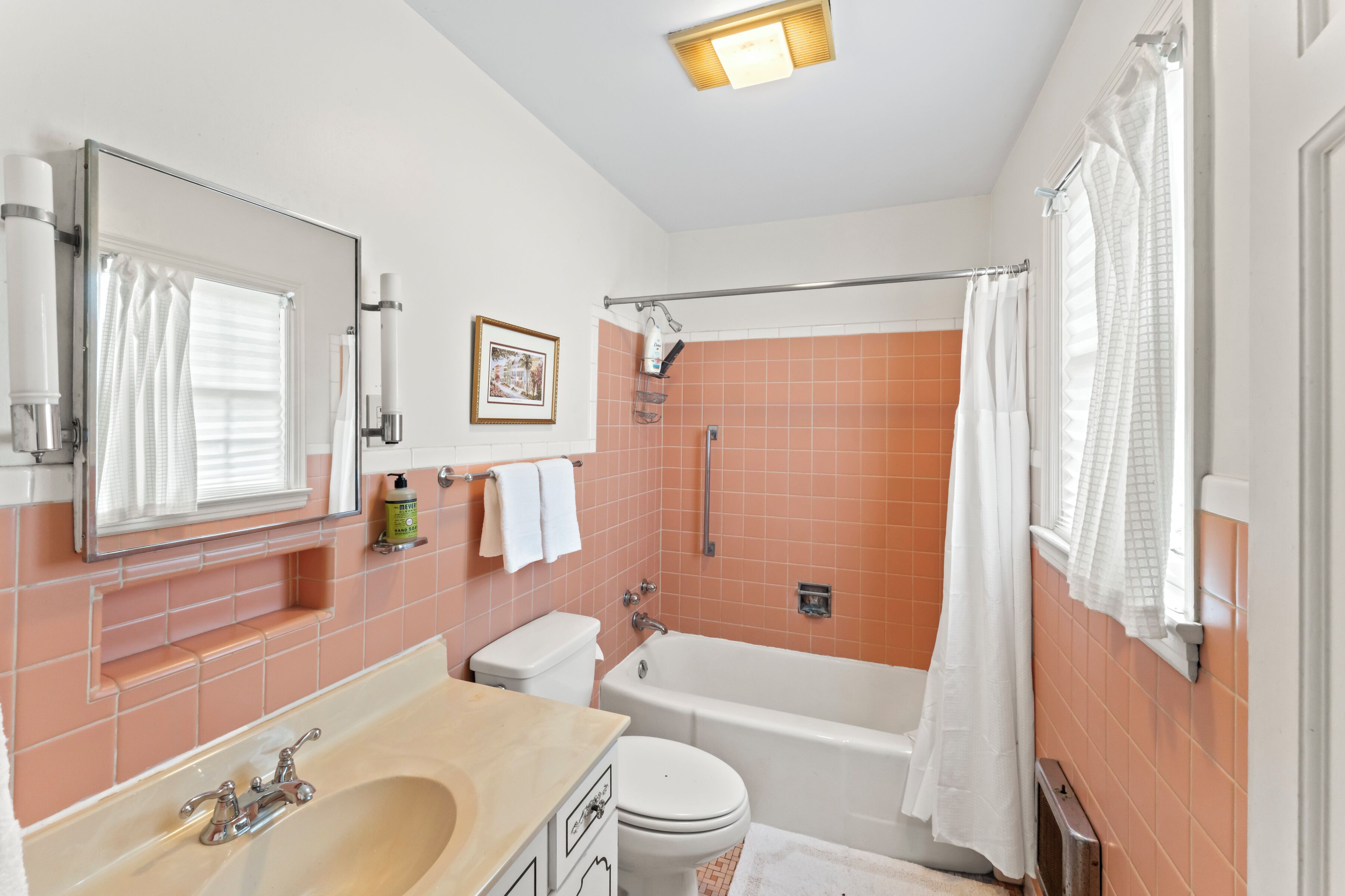 Une salle de bain comprenant une baignoire, des toilettes, un lavabo et un espace douche.