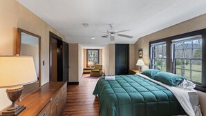 A bedroom with a bed, dresser, and a ceiling fan.
