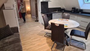 Eine moderne Küche mit Essbereich, Backofen und Fenster zur Straße.