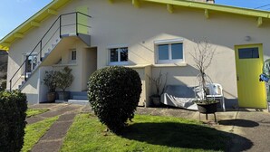 A two-story house with a yellow roof, a chimney, and a staircase leading to the upper floor. - Cosy house with garden - near Mimizan beach (Mimizan)