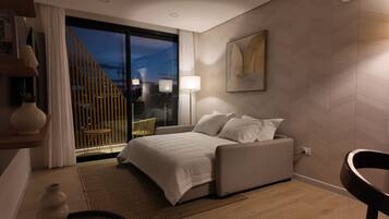 Un dormitorio moderno con cama, una silla, una lámpara, un ventanal con cortinas y vistas al exterior.