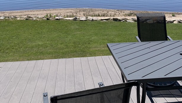 Eine Terrasse mit Blick auf ruhiges Wasser und die Ferne.