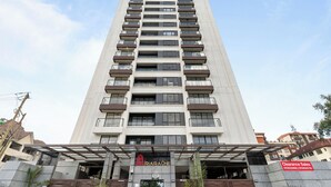 A tall, modern building with multiple balconies and a clear sky. - Luxurious apartment near mall and Carrefour, giving a cozy and homely vibe (Nairobi)