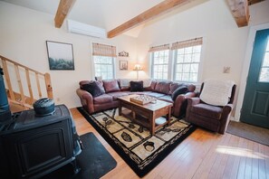 Una sala de estar acogedora con chimenea, un conjunto de sofá y una mesa de centro.