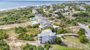 Vista aerea di una zona residenziale costiera con case, una spiaggia e un cielo sereno.