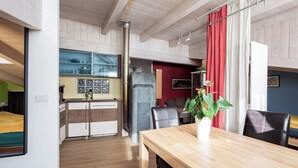 Una cocina moderna con estufa de piedra, armarios de madera y una pared de acento roja.