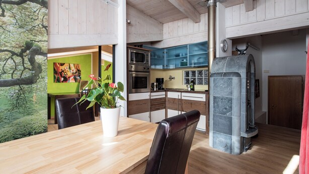 Una cocina moderna con armarios de madera, horno empotrado y horno de piedra.