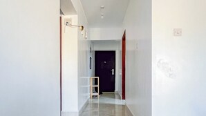 A hallway with white walls, a tiled floor, and a door at the end. - Spacious & Peaceful Getaway in Imara Daima (Nairobi)