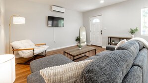 Un salon moderne avec un canapé, un fauteuil et une table basse.