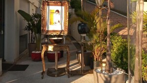 An outdoor area with a decorative table, a framed picture, and potted plants. - Compacto Hotel Campinas (Campinas)