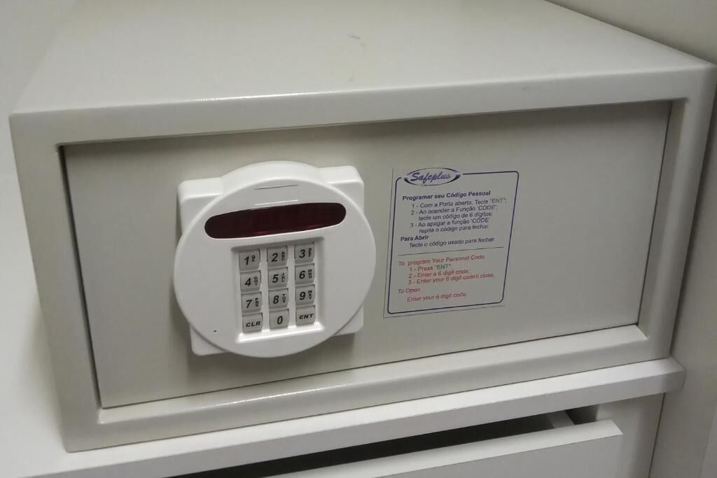 Cerradura electrónica con teclado en un gabinete blanco, con una etiqueta que indica cómo programar un código personal.