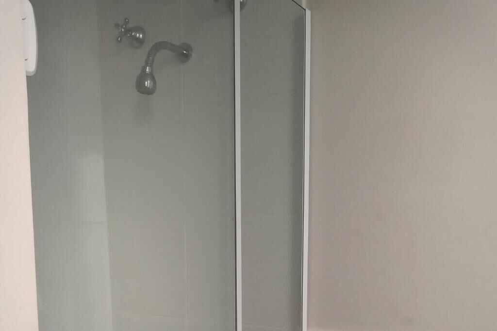 A shower with a glass door and a faucet.