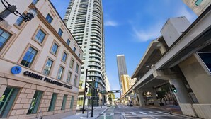 A tall building with a curved facade, a street with a crosswalk, and a sign for Christ Fellowship Church. - 501 First Residences (Miami)