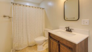 A bathroom with a toilet, a sink, and a shower curtain.