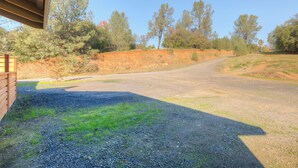 A gravel driveway leading to a wooden building with a sloped roof.