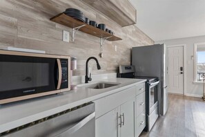 Eine moderne Küche mit Mikrowelle, Spüle und Kühlschrank.