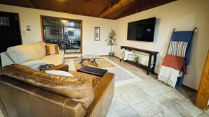 A living room with a leather sofa, a coffee table, a TV, and a fireplace. - This special place is close to everything, making it easy to plan your visit. (Quitman)