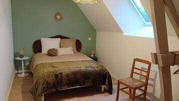 Ein Schlafzimmer mit Bett, Stuhl, Lampe und Fenster.
