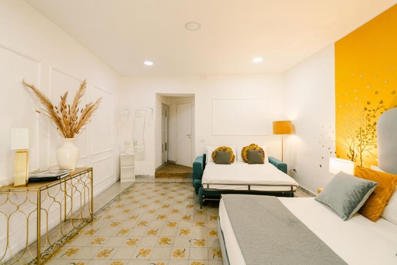 Une chambre à coucher moderne avec un lit, une table de chevet, une lampe et des plantes décoratives.
