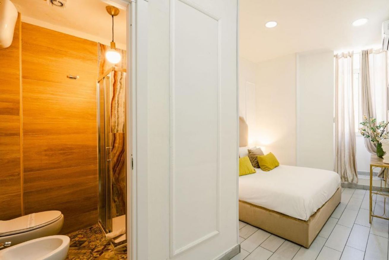 Une salle de bain moderne avec un meuble-lavabo en bois, une cabine de douche en verre et des toilettes blanches.