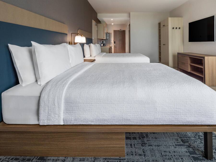 Una habitación de hotel con una cama grande, televisor, escritorio y armario.