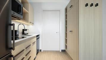 A modern kitchen with a built-in microwave, a coffee maker, and a stainless steel refrigerator.