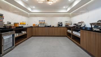 A modern kitchen with a marble backsplash, wooden cabinets, and a built-in coffee station.