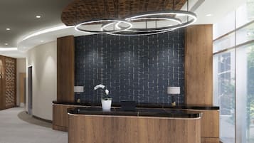 A reception area with a curved wooden reception desk, a dark patterned wall, and a modern light fixture.