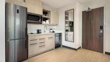 A modern kitchen with stainless steel appliances, wooden cabinets, and a built-in microwave.