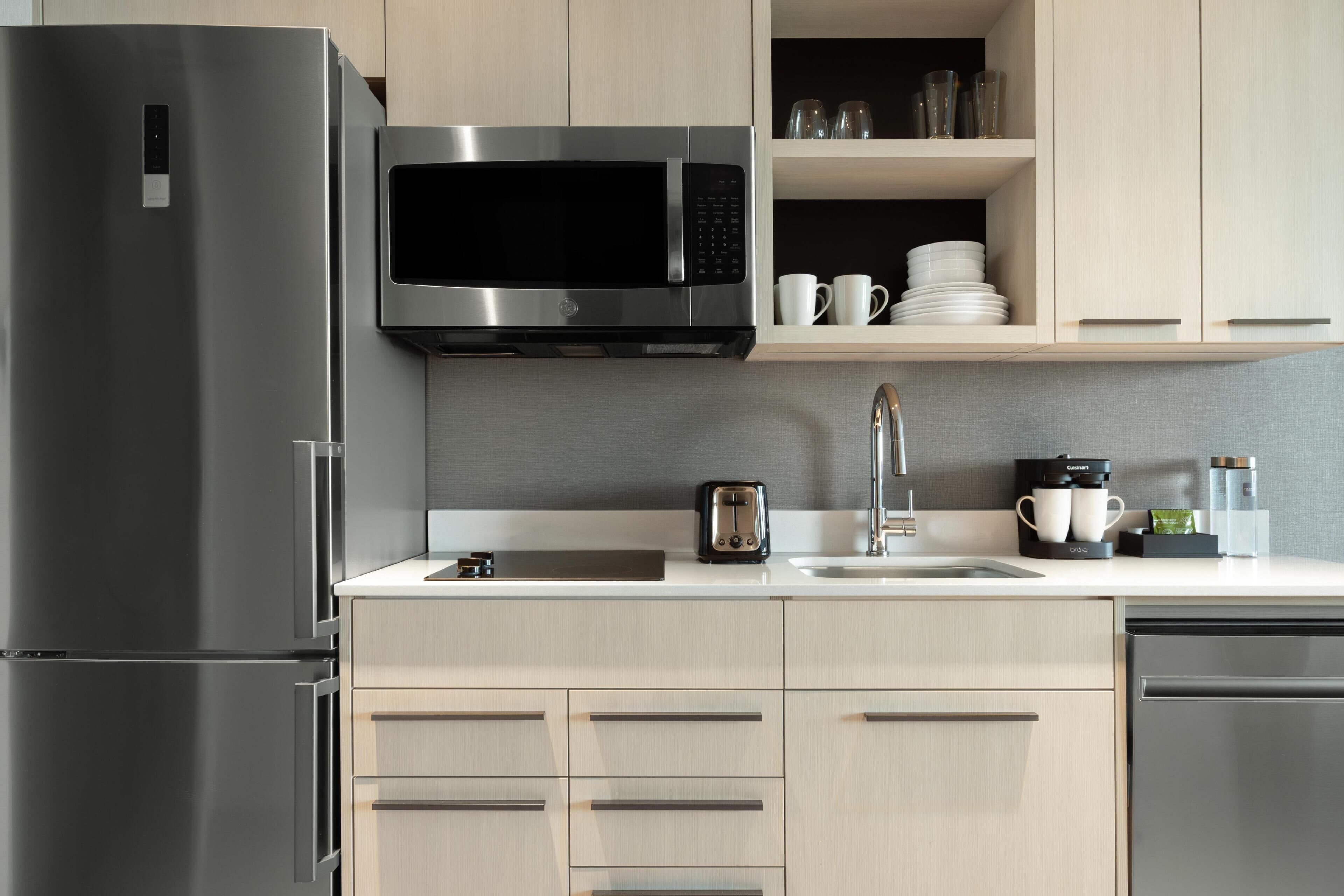 A modern kitchen with stainless steel appliances, a microwave, a toaster, and a coffee maker.