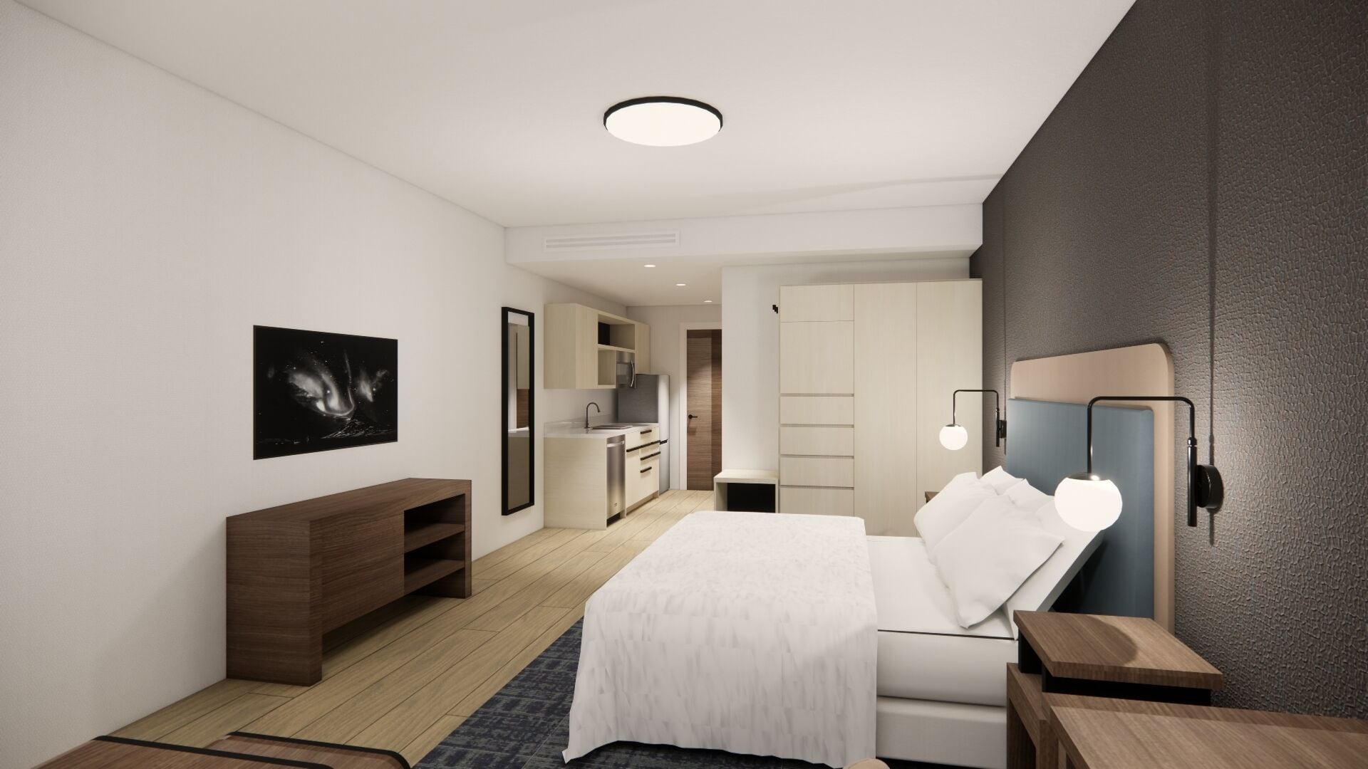 A modern hotel room with a large bed, a wooden dresser, a desk, and a kitchenette.
