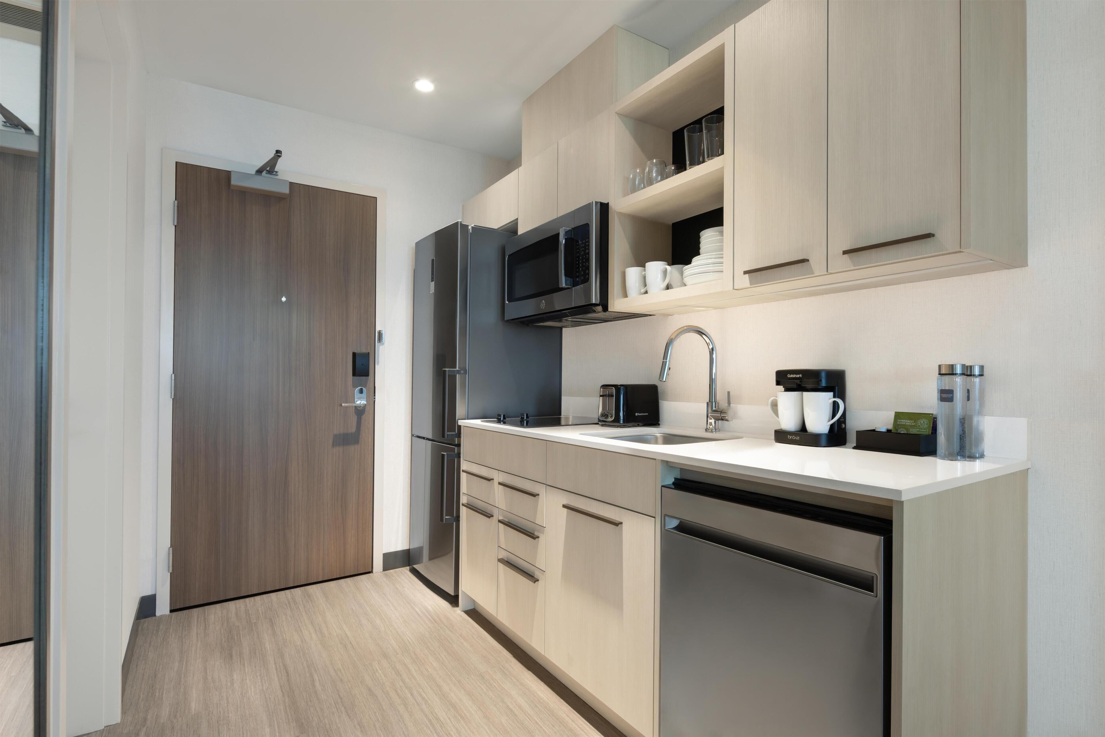 Eine moderne Küche mit Mikrowelle, Kühlschrank und Geschirrspüler.