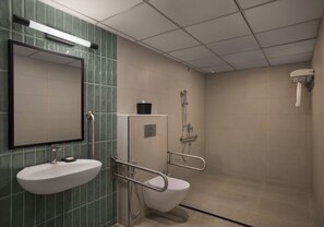 A bathroom with a sink, mirror, toilet, and shower.
